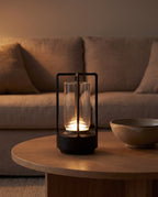 Zermatt black lantern lamp on an oak coffee table at dusk